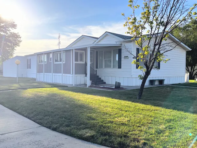 White siding exterior featuring dark shutters and a covered porch entry