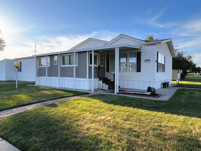 White vinyl siding exterior with an attached covered porch and complementary gray accent siding