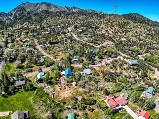 Mountainous terrain featuring a clear blue sky, varied topography, and established properties