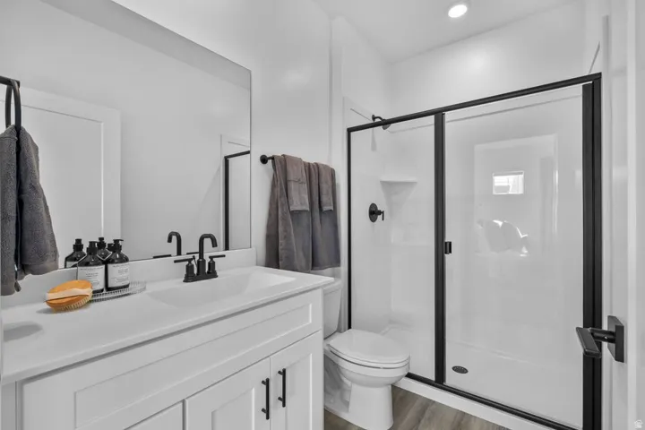 Bathroom featuring a white vanity with a rectangular sink, matte black faucet, and a large frameless mirror