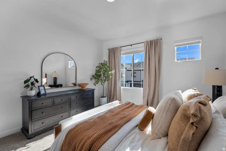 Bright interior space featuring white walls, carpeted flooring, and two distinct window styles