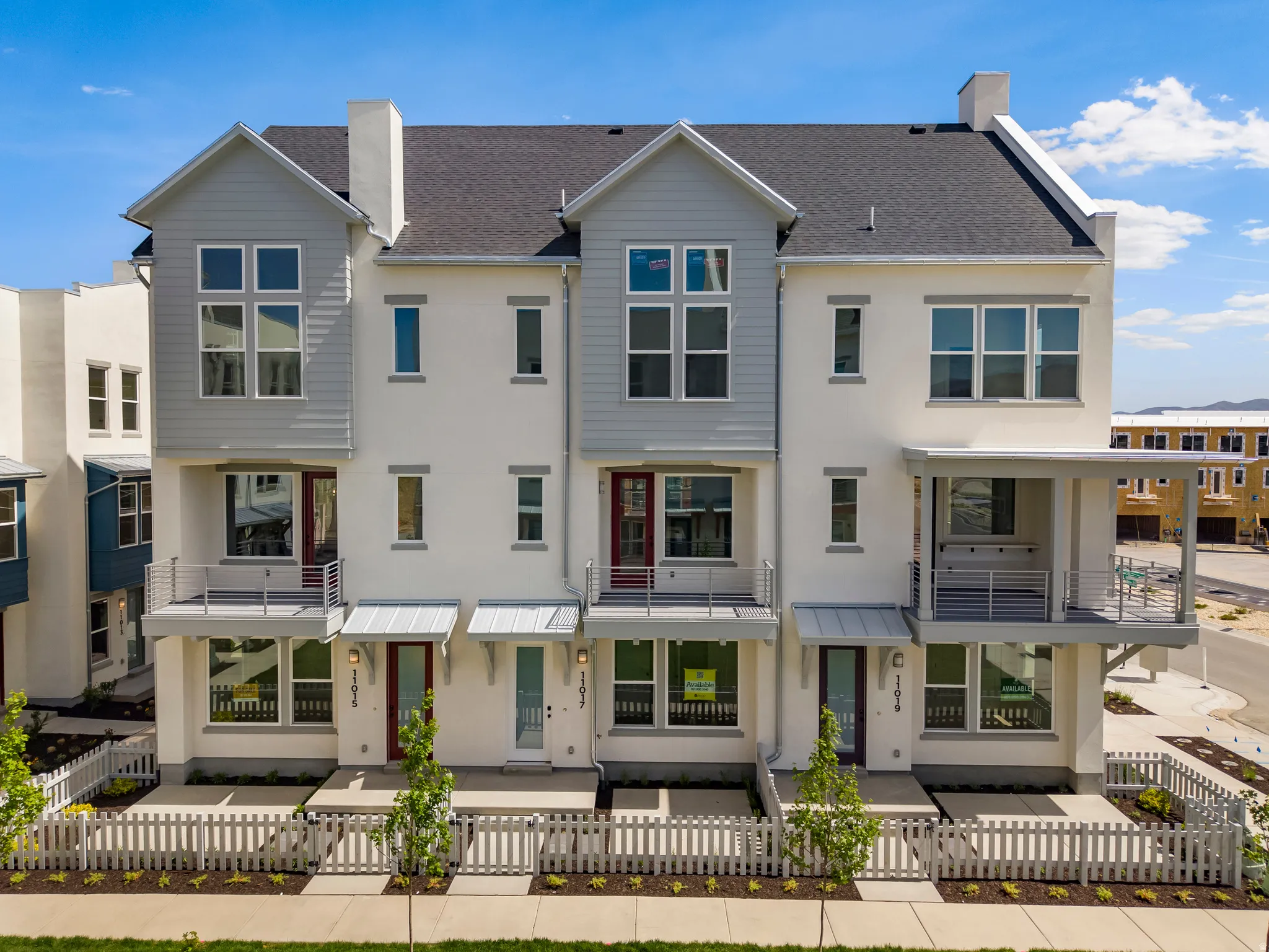 Contemporary townhome exterior featuring a stucco finish and vertical siding accents
