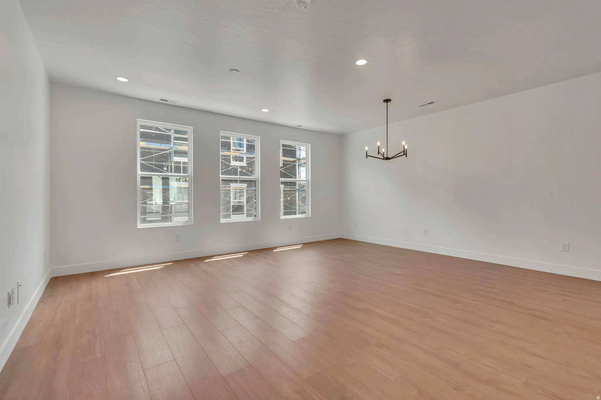 Spacious interior featuring wood-finish flooring, recessed lighting, and a contemporary chandelier