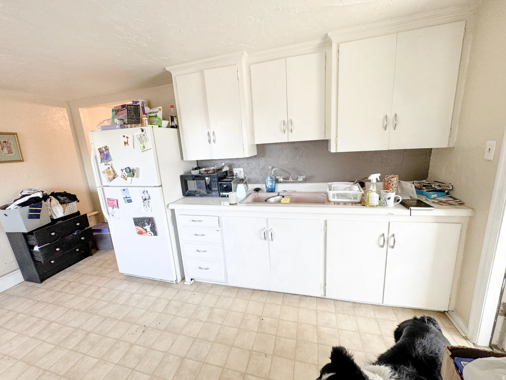 Kitchen featuring white cabinetry and light-toned, checkered tile flooring