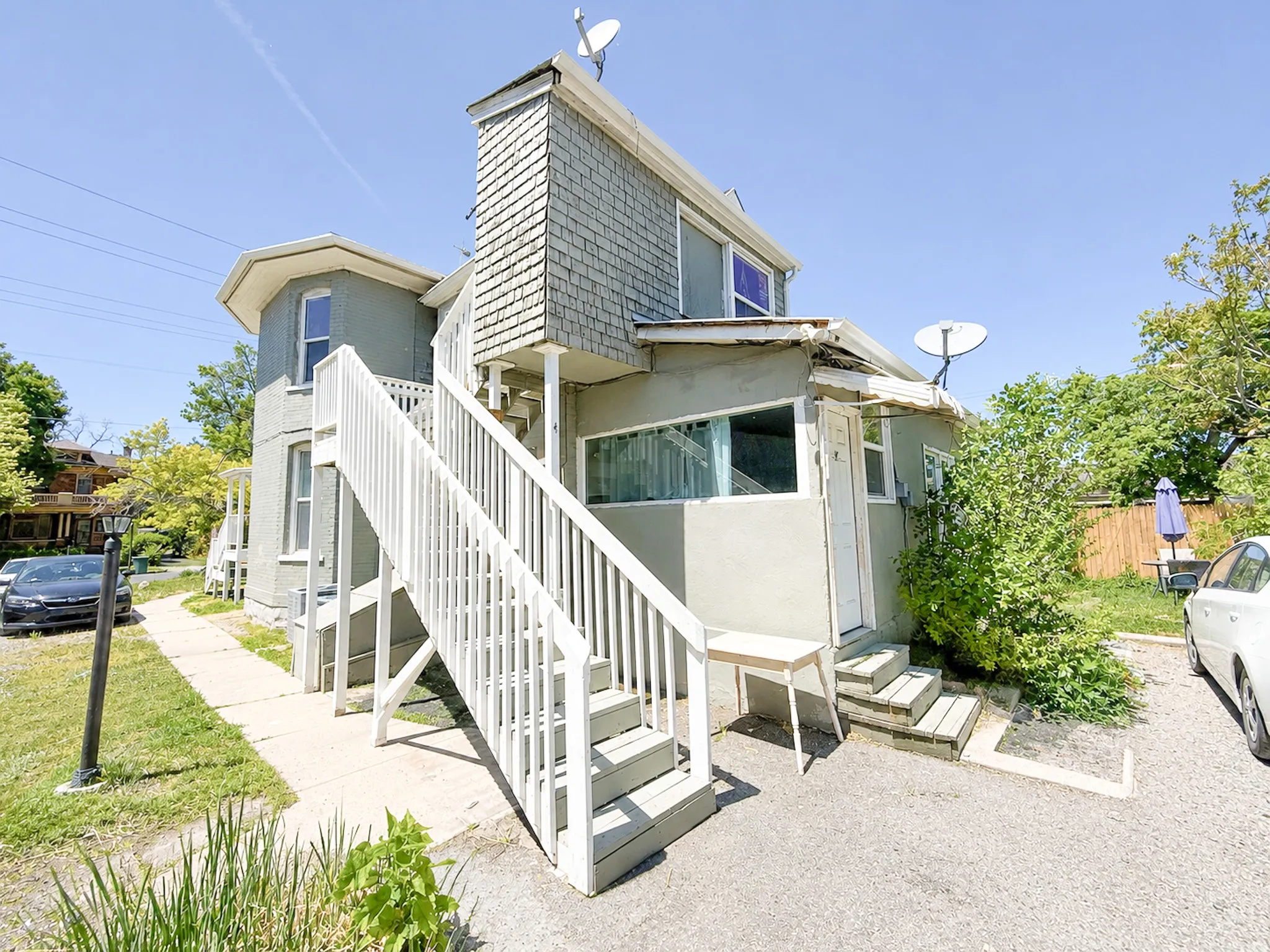 Exterior facade featuring a prominent white staircase and a shingled upper section