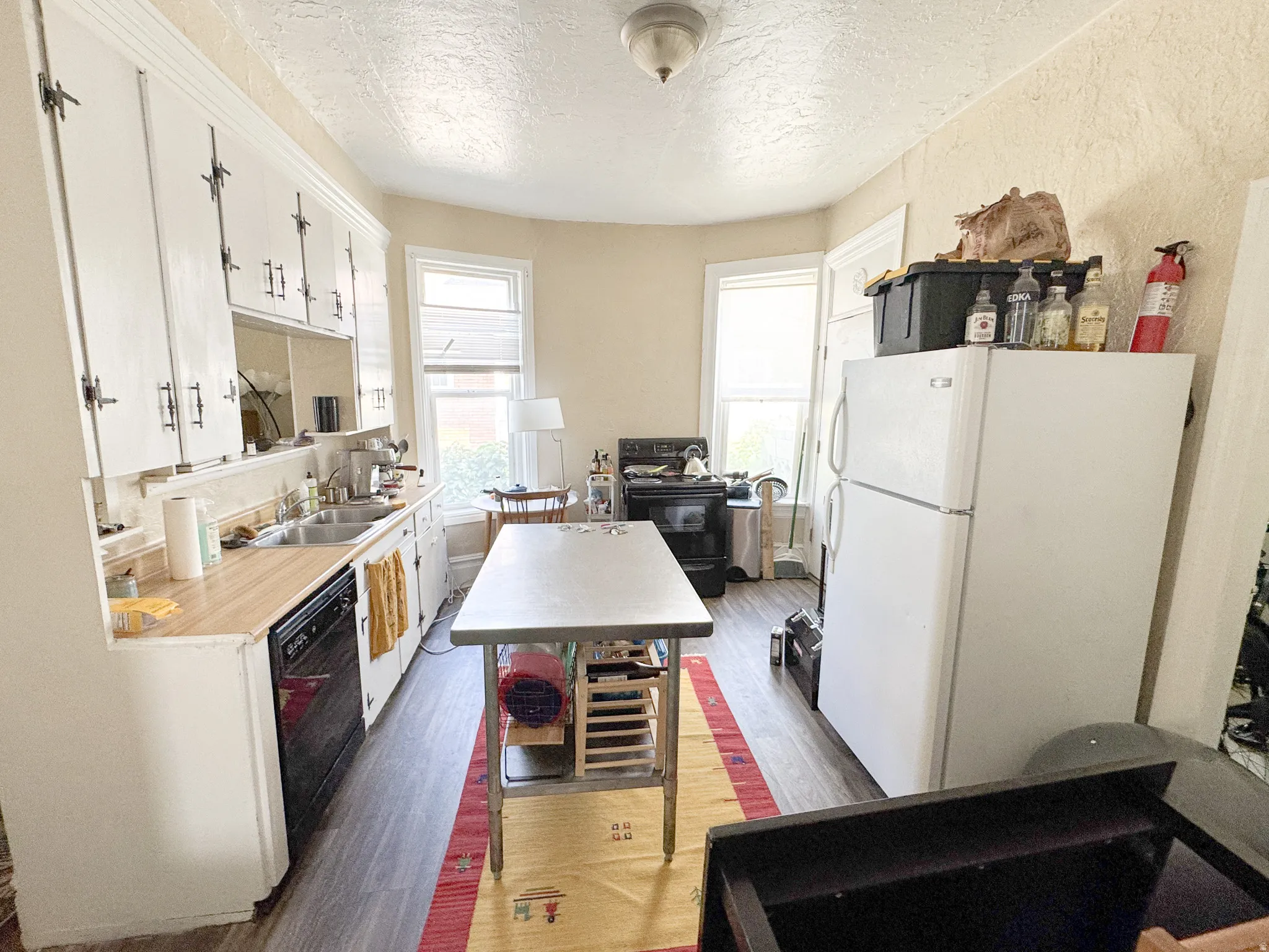 Kitchen featuring white cabinetry, wood-finish countertops, and a dual basin stainless steel sink