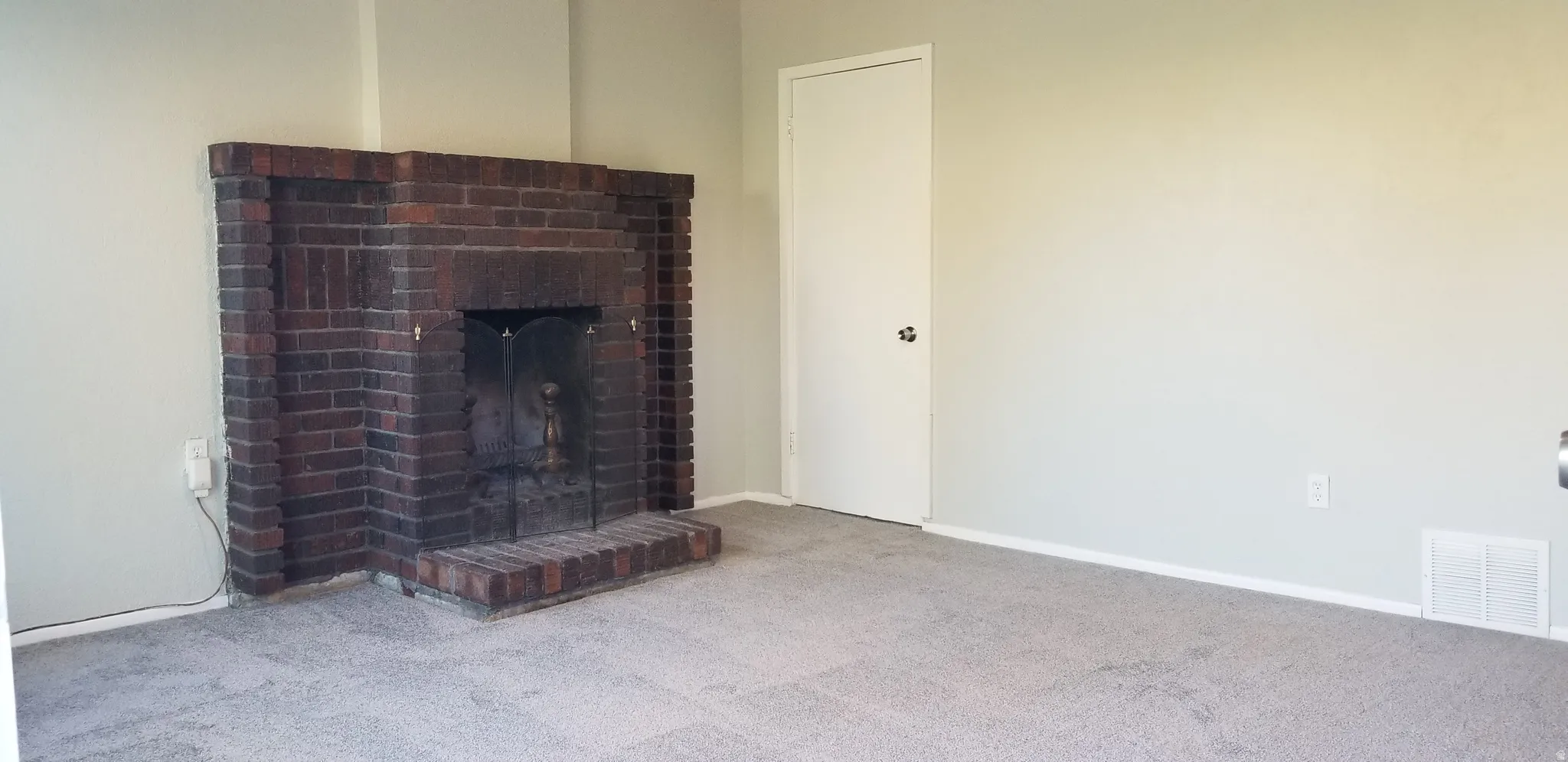 Brick fireplace with hearth and metal fire screen