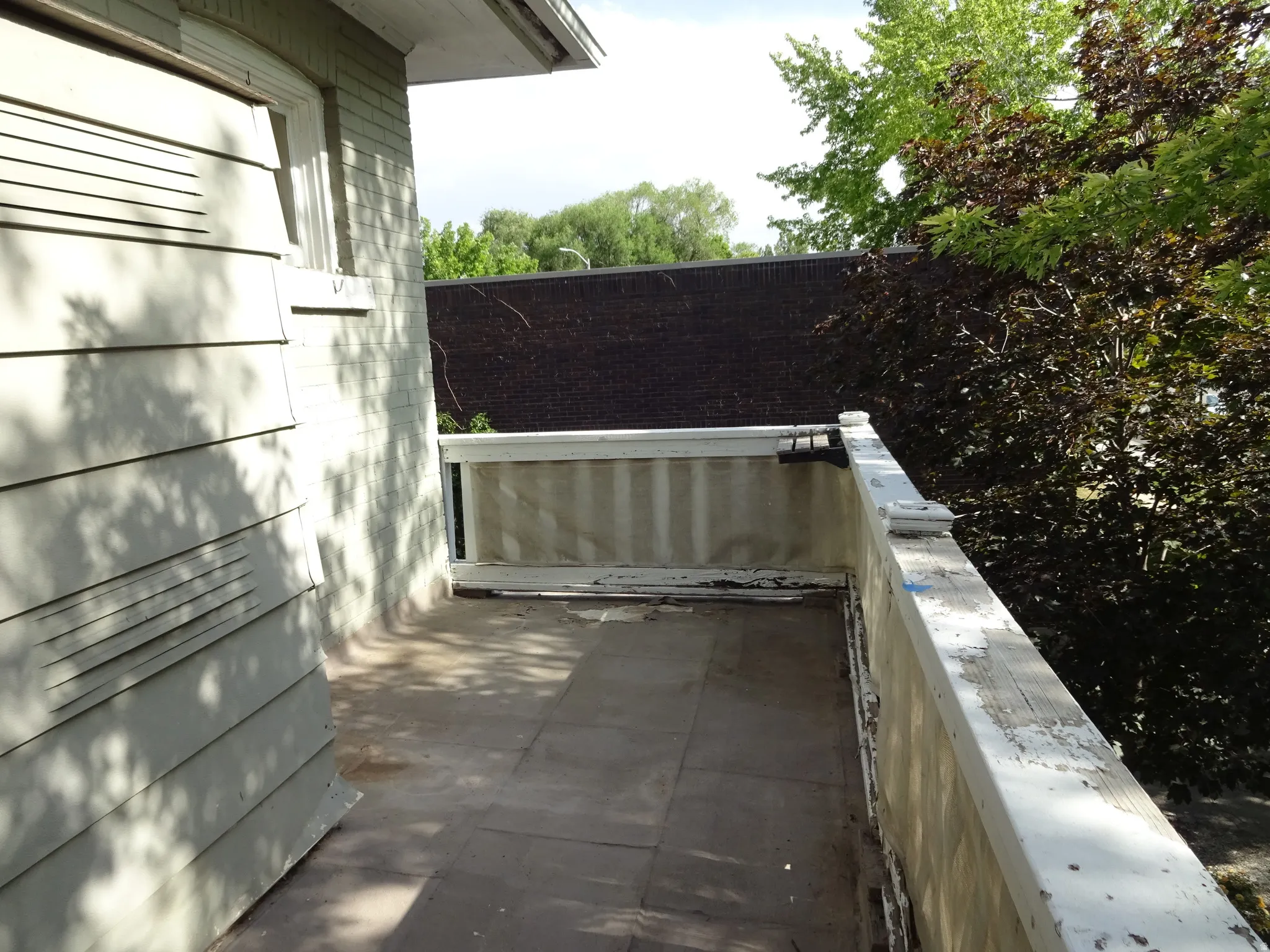 Outdoor balcony featuring tile flooring and a painted railing