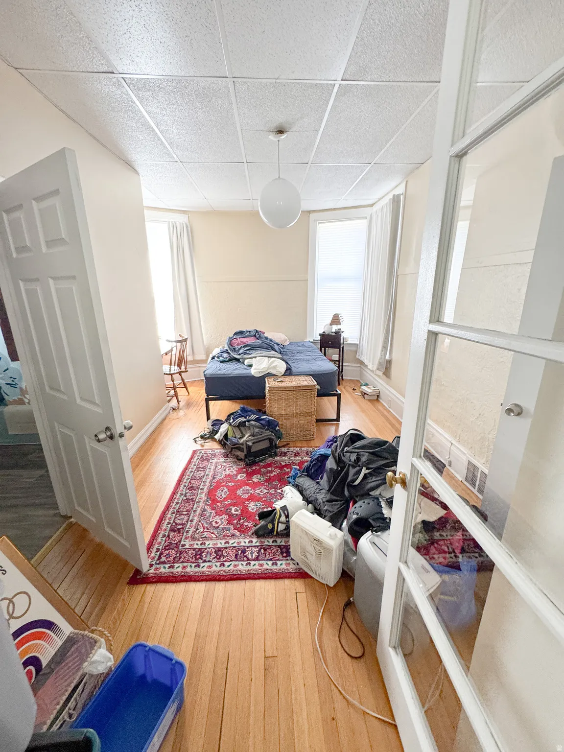 Bedroom featuring wood-finish flooring, a decorative area rug, and a bay window with natural light