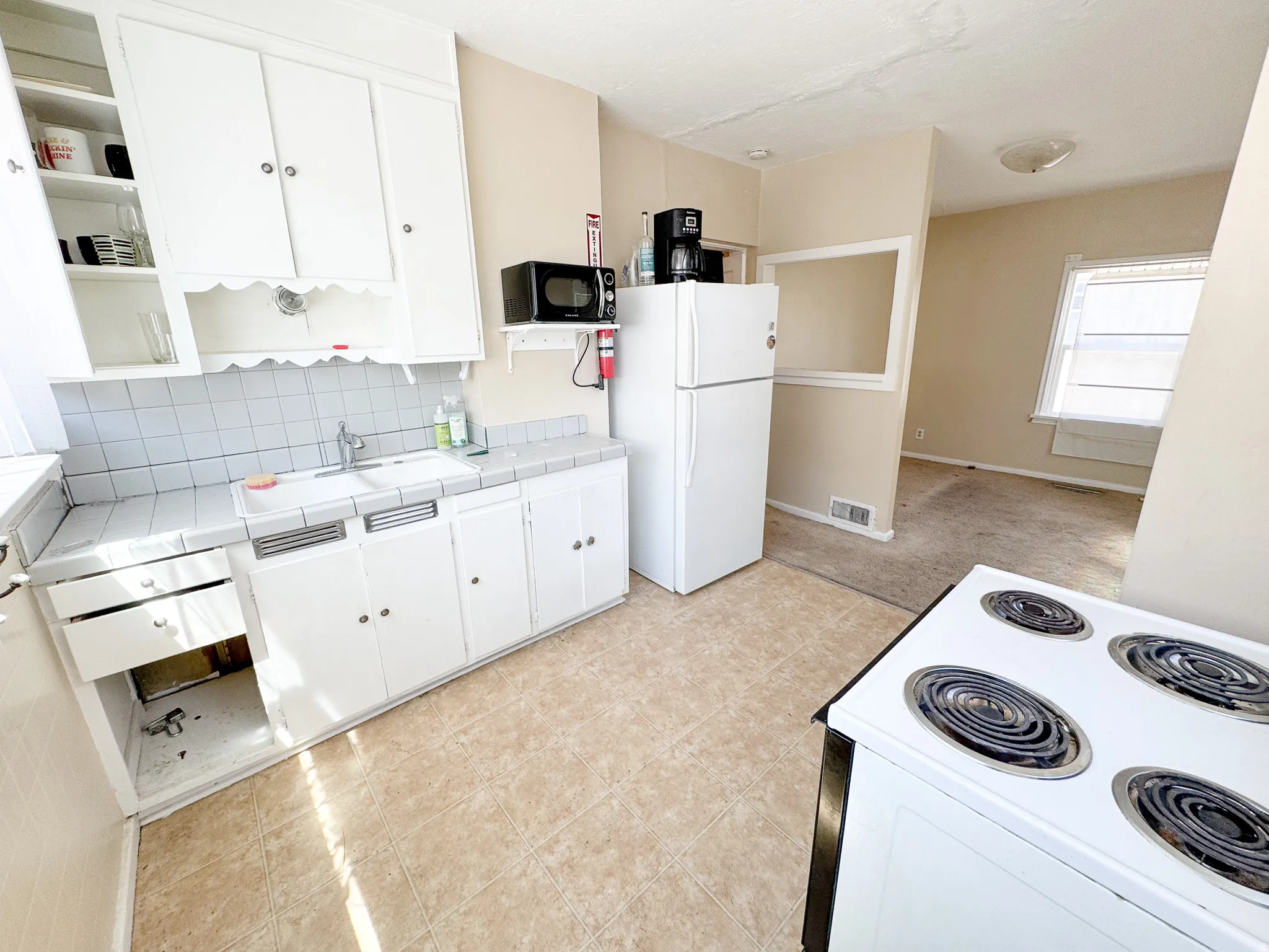 Kitchen featuring white cabinetry, tile countertops, and tiled flooring