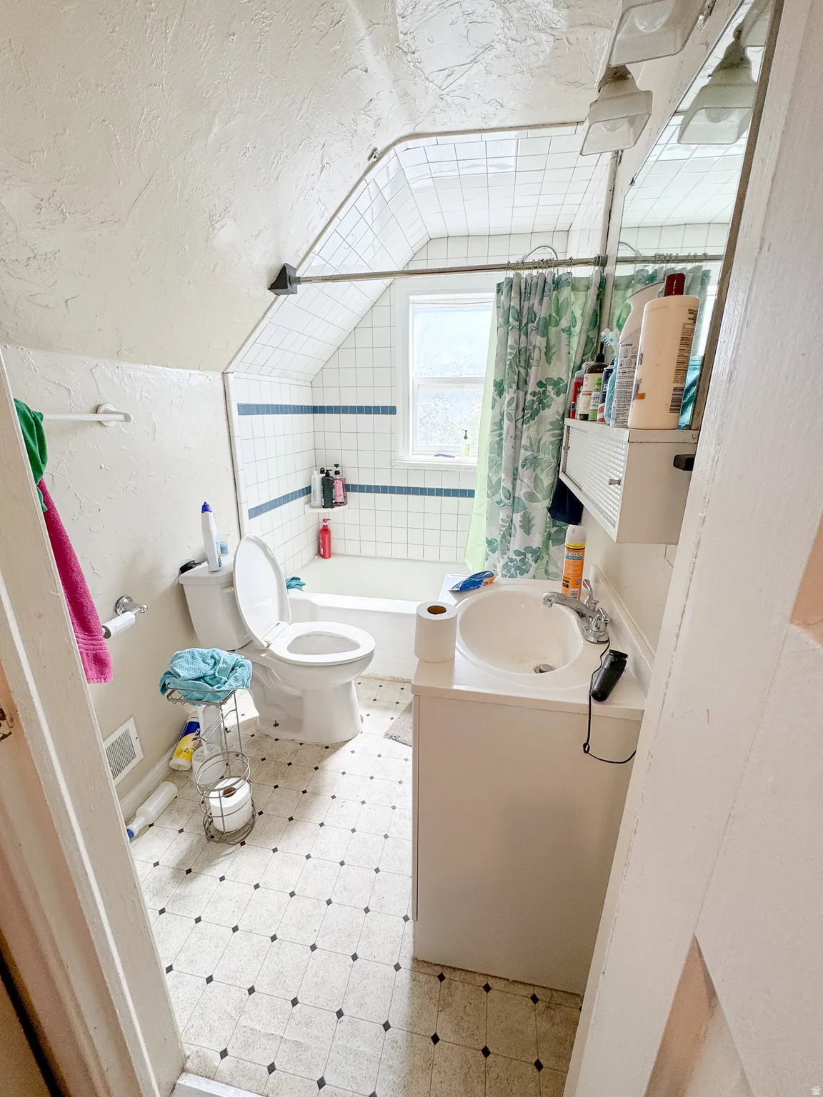 Bathroom featuring white subway tile surround, integrated bathtub, and a window for natural light