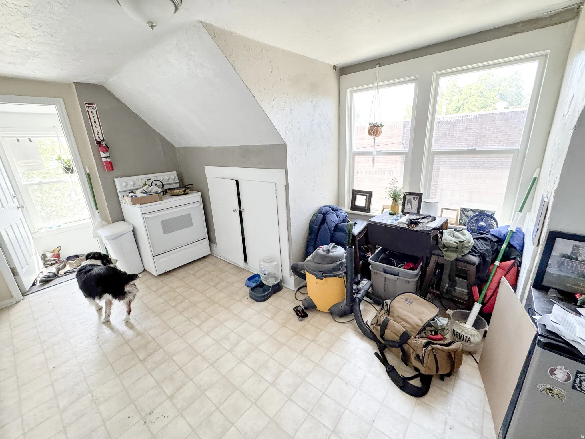 Kitchen area featuring a white range, light-toned tiled flooring, and multiple windows