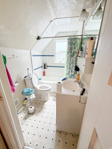 Bathroom featuring white subway tile surround, integrated bathtub, and a window for natural light