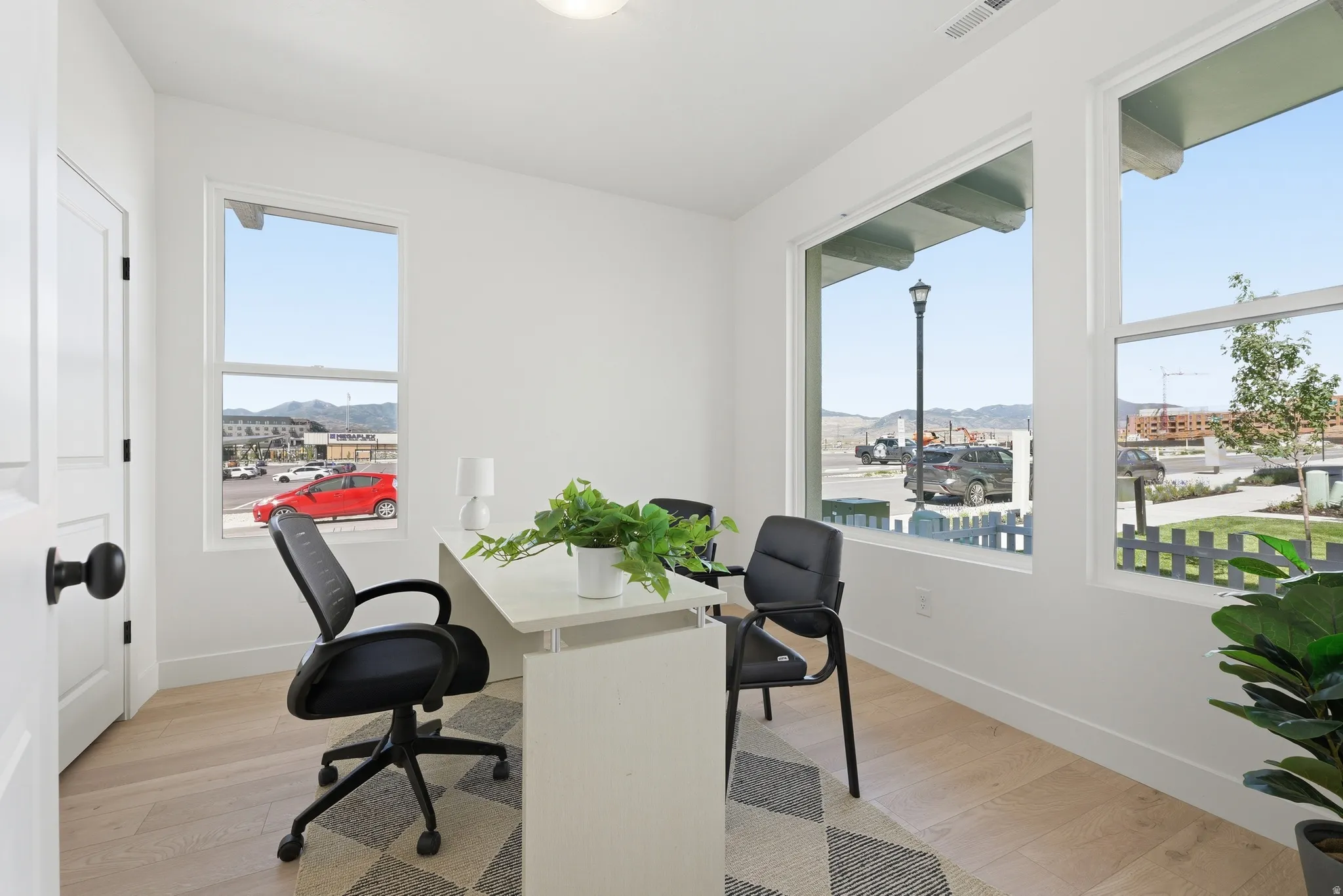 Bright interior space featuring light wood-finish flooring and multiple windows
