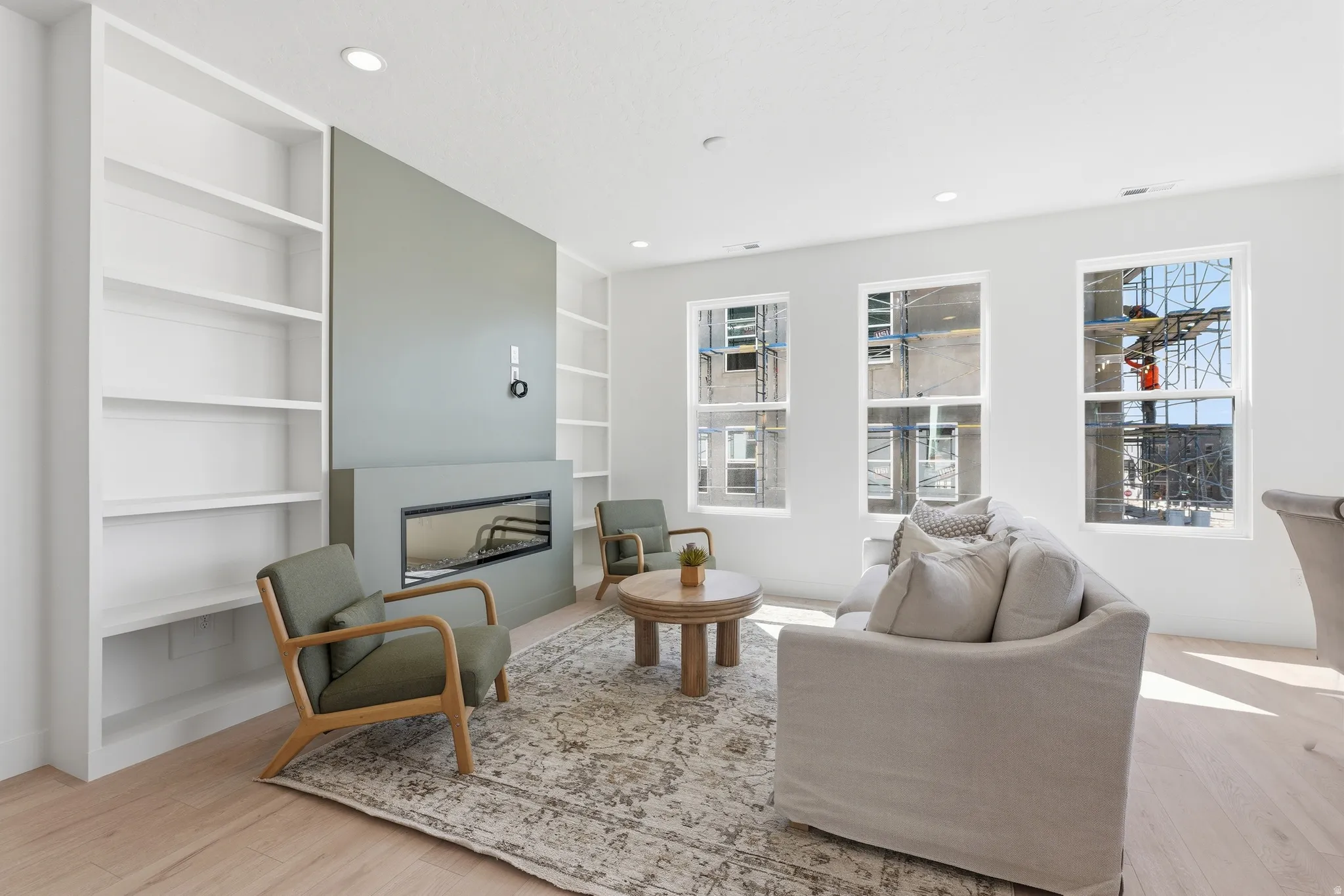 Recessed electric fireplace with a contrasting accent wall, flanked by built-in shelving
