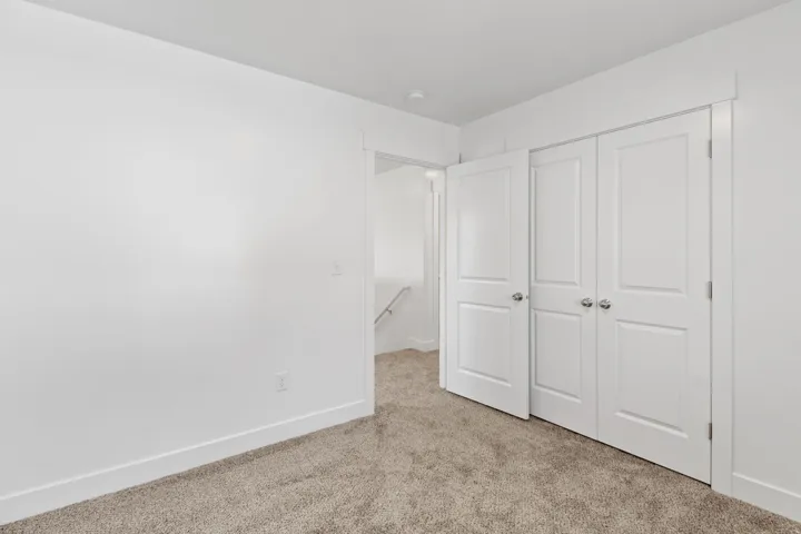 Neutral color palette featuring light beige carpet and white walls