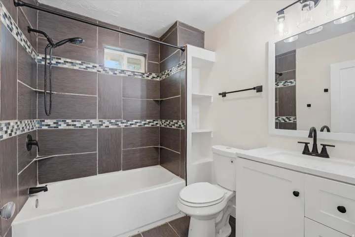 Contemporary bathroom featuring a white vanity with a single basin sink, matte black fixtures, and a framed mirror