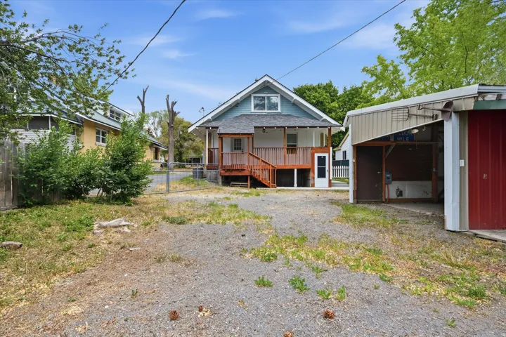 Rear exterior featuring a blue siding, white trim, and a red-stained wood deck with stairs