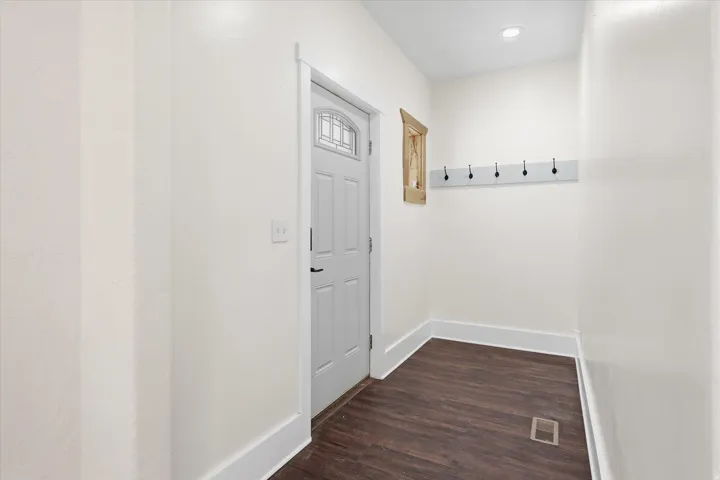 Entryway featuring wood-finish flooring, white trim, recessed lighting, and a five-hook coat rack