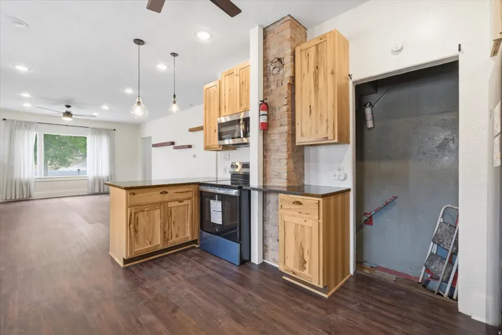 Kitchen and living area featuring LVP flooring, recessed lighting, and a window with white trim