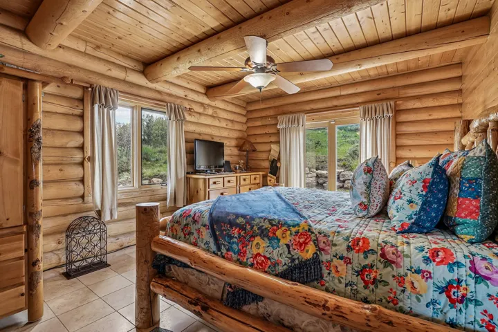 Natural wood log construction throughout, featuring a plank wood ceiling with exposed beams