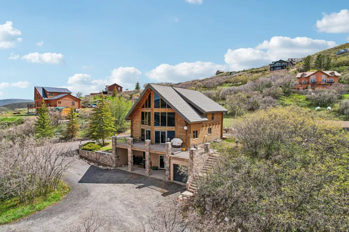 Rustic-style home featuring a log exterior and a prominent A-frame architectural element