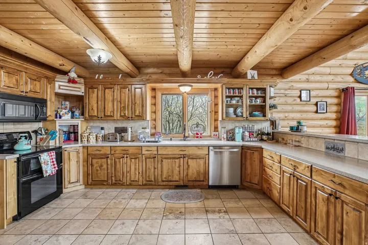 U-shaped kitchen featuring wood cabinetry, stainless steel appliances, and a tiled backsplash