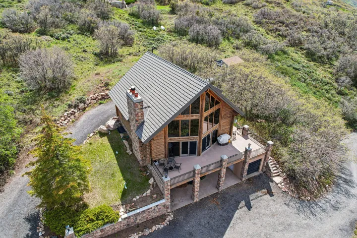 Rustic wood-sided home featuring a stone chimney and a metal roof