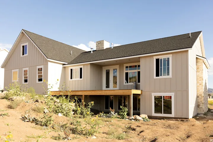 Light-toned exterior with multiple windows and a dark shingle roof