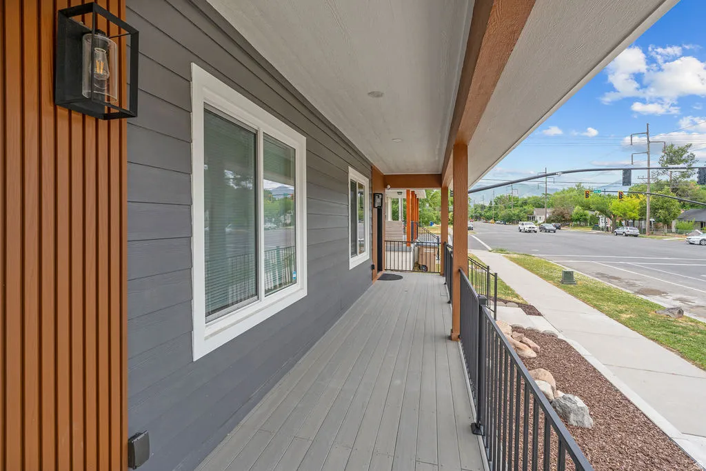 Covered front porch featuring wood-finish siding accents and a contrasting gray facade