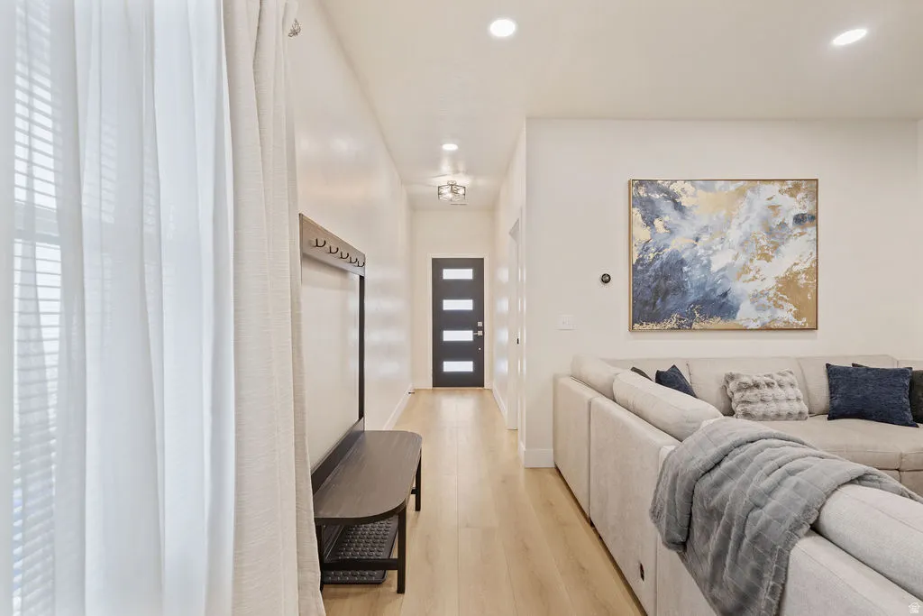 Entryway featuring light wood-finish flooring, recessed lighting, and a modern dark-paneled door