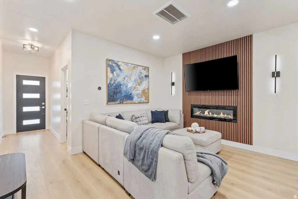 Living area featuring a slat wood-finish accent wall with an integrated linear fireplace