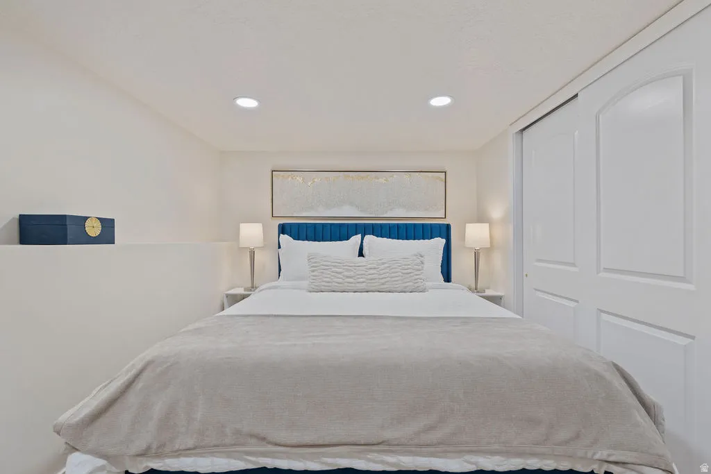 Interior room featuring a built-in half-wall, recessed lighting, and a sliding closet door with arched paneling