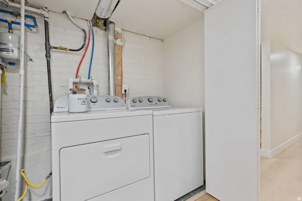 Dedicated laundry area featuring a white top-load washing machine and front-load dryer