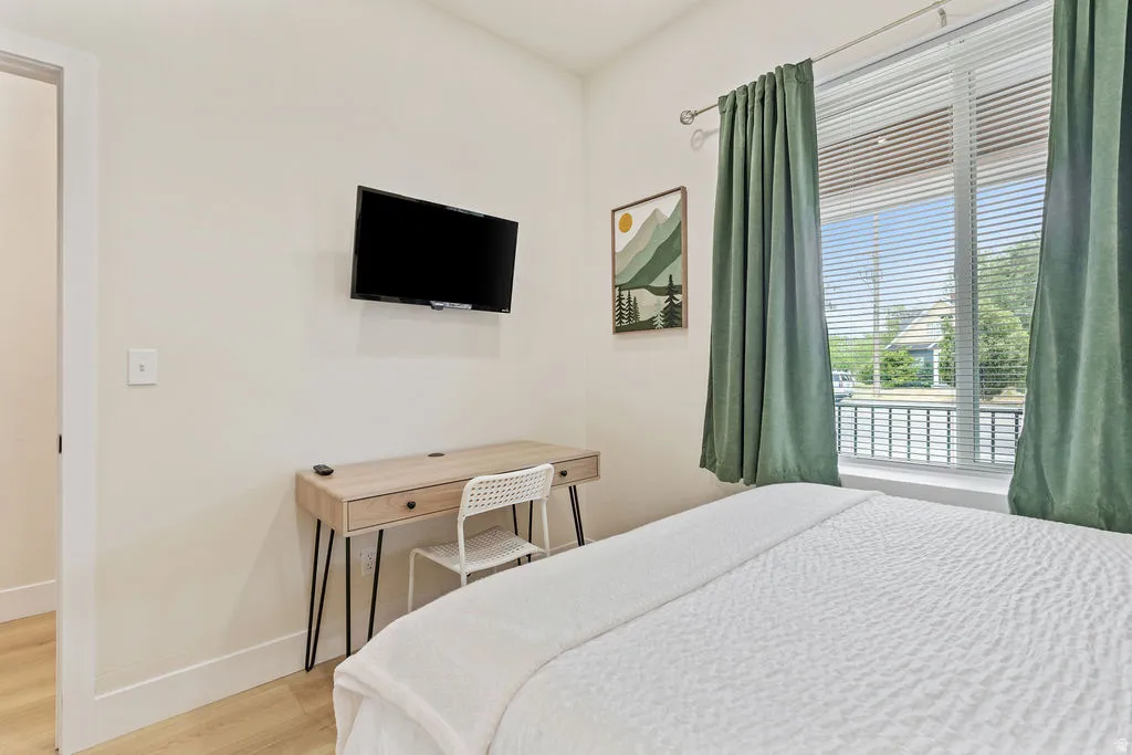 Light-filled room featuring neutral wall tones and wood-finish flooring