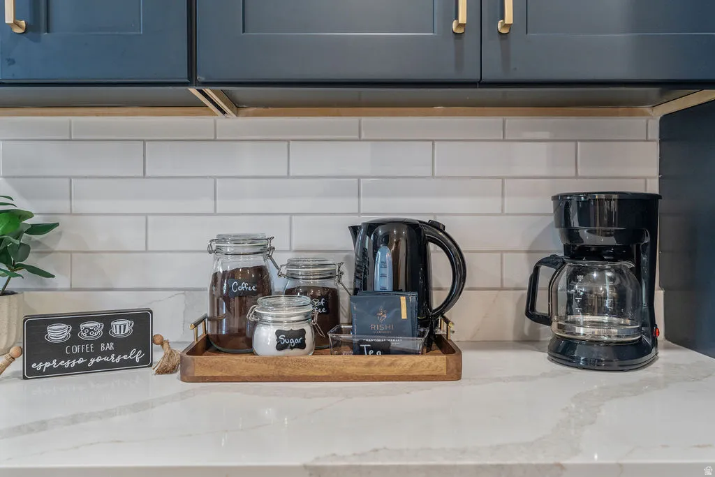 Kitchen counter featuring a white subway tile backsplash and a light-colored countertop with subtle veining