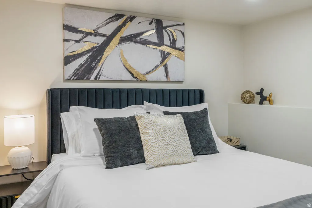 Panel upholstered headboard with vertical channeling, white walls, and a built-in wall ledge
