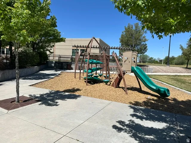 Outdoor play area featuring a multi-level structure with a green slide