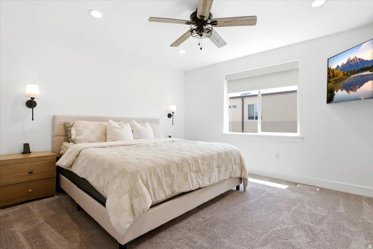 Bedroom with neutral carpet flooring, recessed lighting, and a ceiling fan