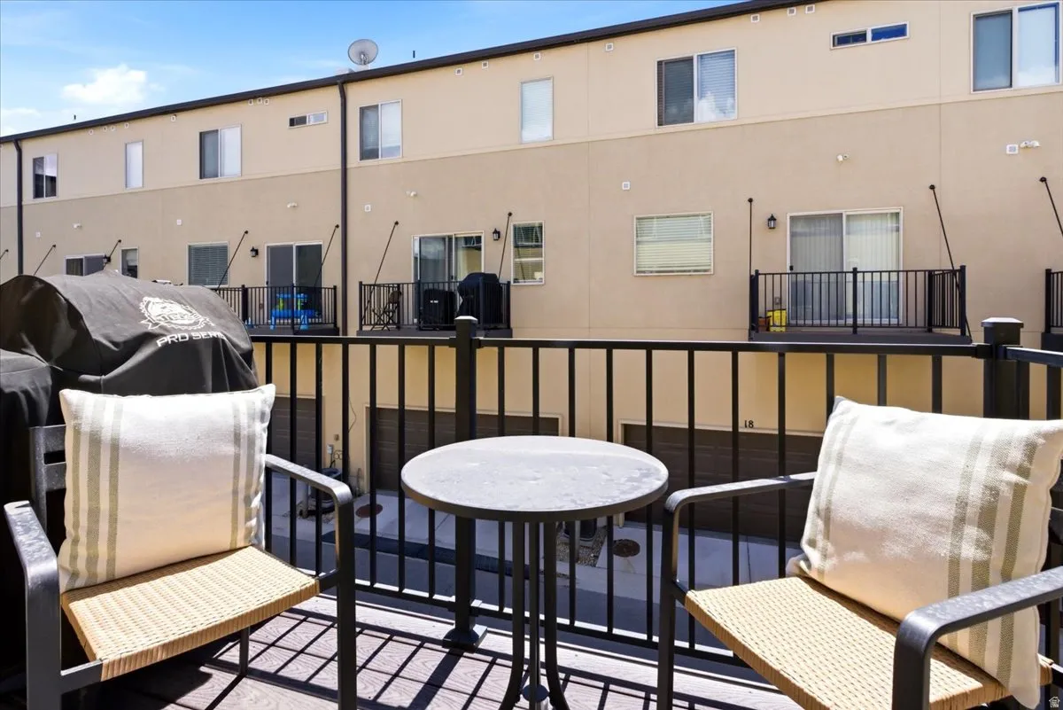 Private balcony featuring dark wood-finish decking and black metal railings