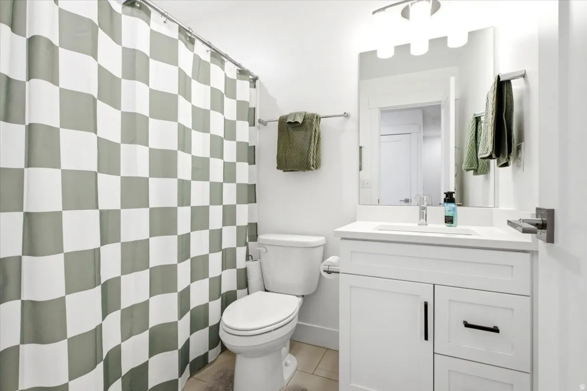 Bathroom featuring a white vanity with shaker-style cabinetry, a white countertop, and a rectangular undermount sink