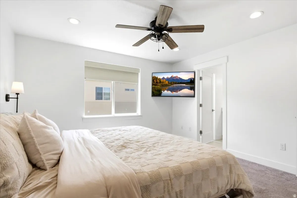 Bedroom featuring a ceiling fan with wood-look blades, recessed lighting, and a wall-mounted sconce