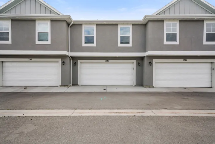 Townhome exterior featuring gray stucco siding and white trim