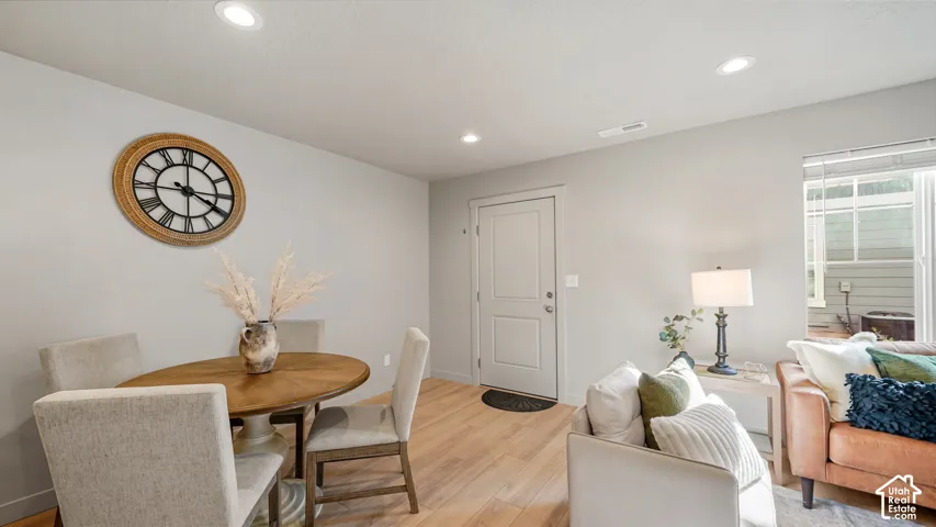 Recessed lighting, wood-finish flooring, and white walls with a built-in window