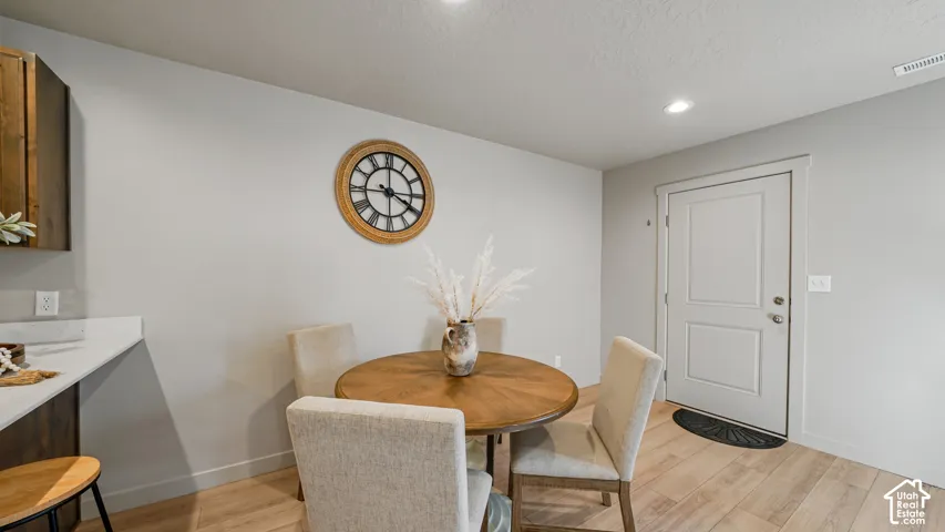 Wood-finish flooring, recessed lighting, and a paneled interior door