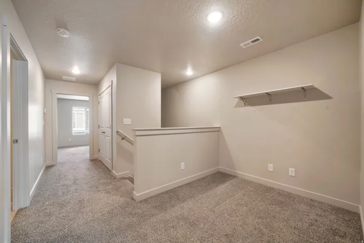 Carpeted landing area/loft featuring recessed lighting, a built-in wall shelf, light neutral wall paint
