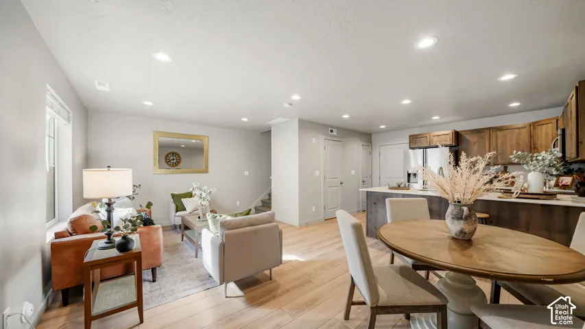 Open-concept living area featuring light wood-finish flooring, recessed lighting, and neutral wall tones