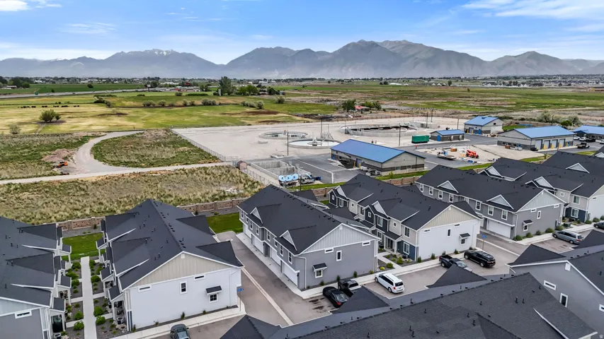 Aerial perspective showcasing a community of multi-story residences with dark shingle roofs and light-colored siding