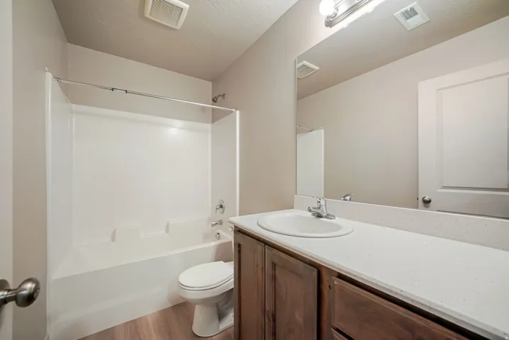 Bathroom featuring a white bathtub and shower combination with chrome fixtures