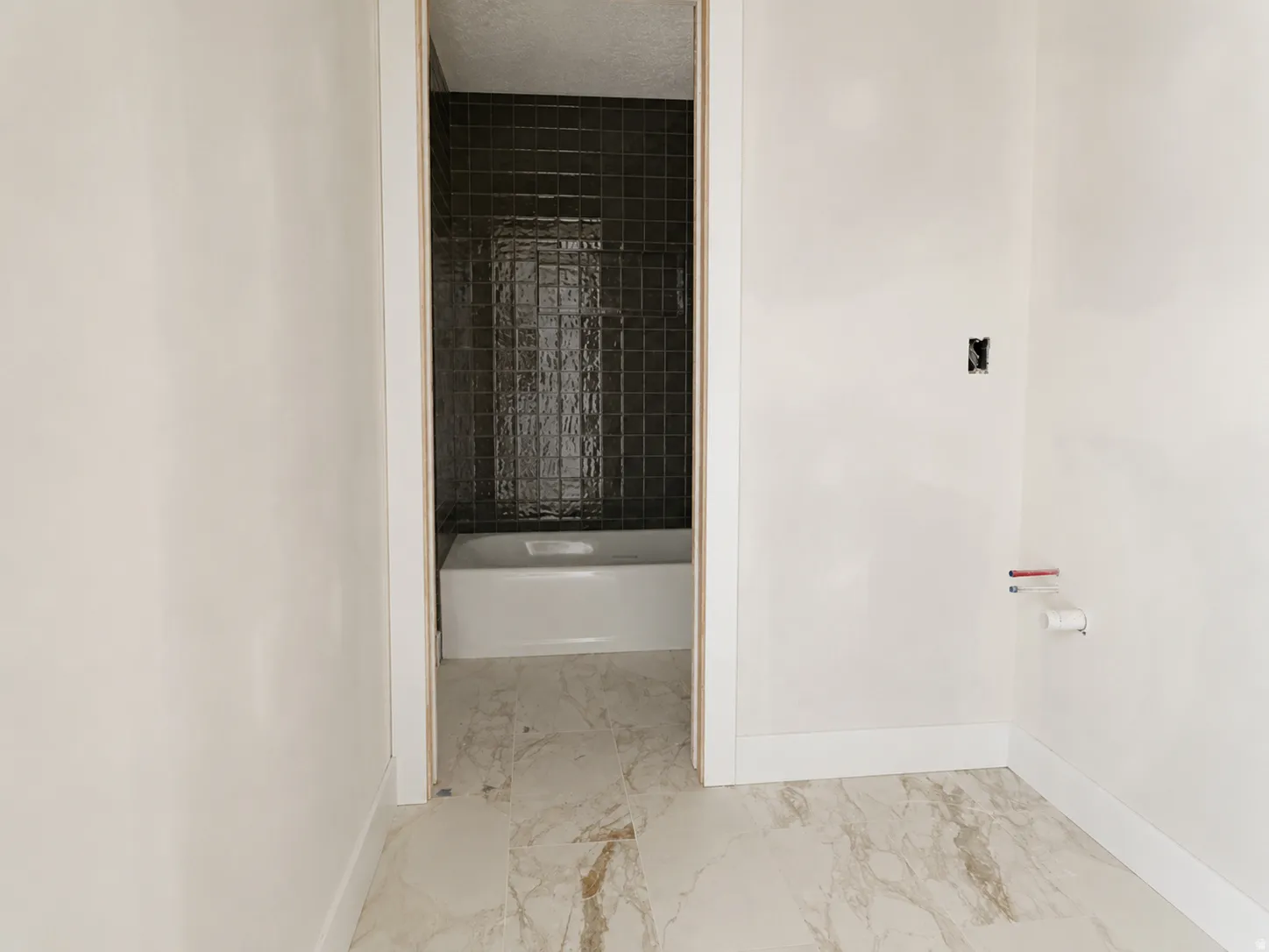 Bathroom featuring marble-look flooring and white baseboards